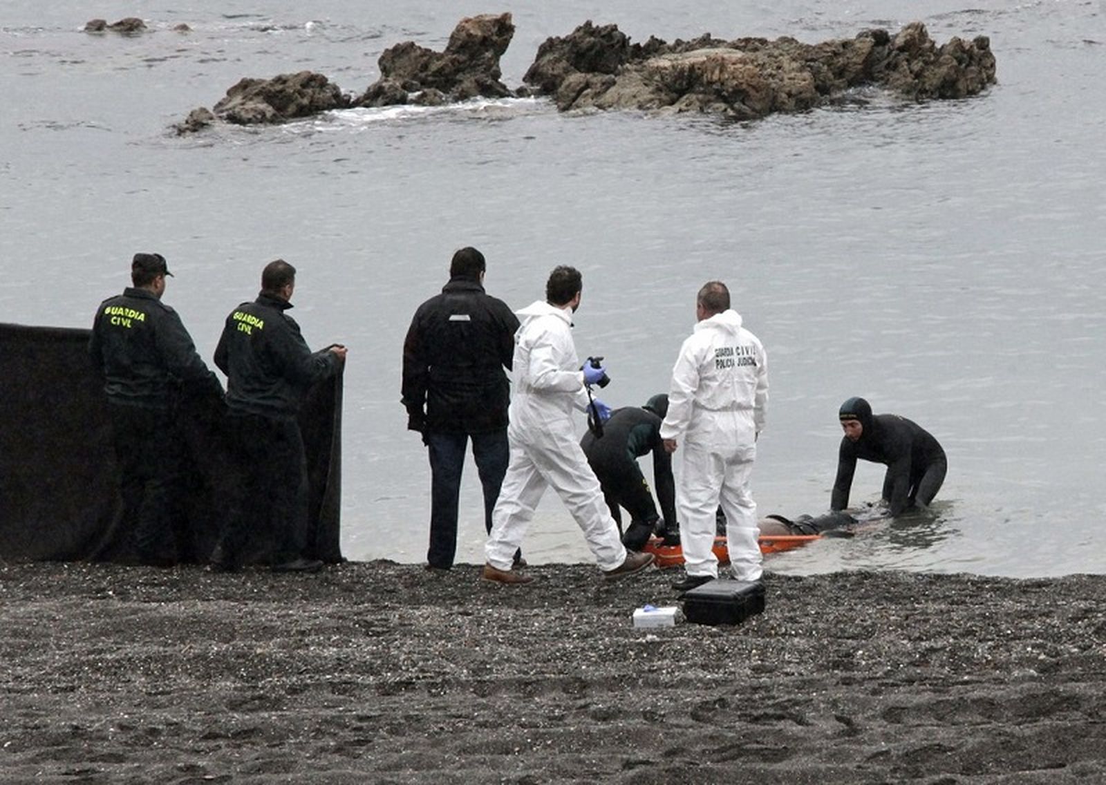 Agentes de la Guardia Civil recuperan el cuerpo de un migrante en aguas de Ceuta en una foto de archivo. / FOTO REDUAN