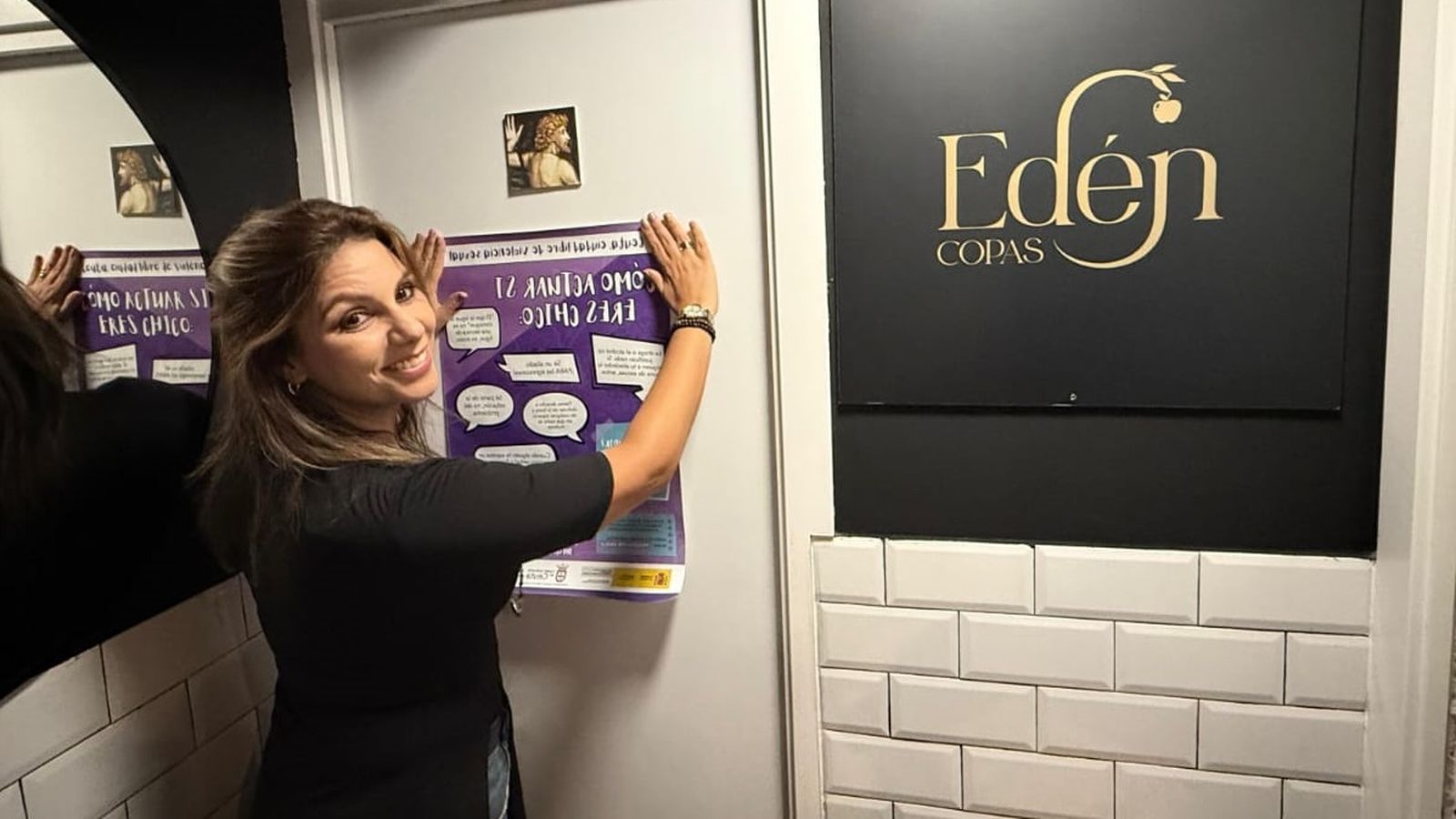 La consejera Nabila Benzina pegando un cartel relacionado con el 'punto violeta' en el Edén