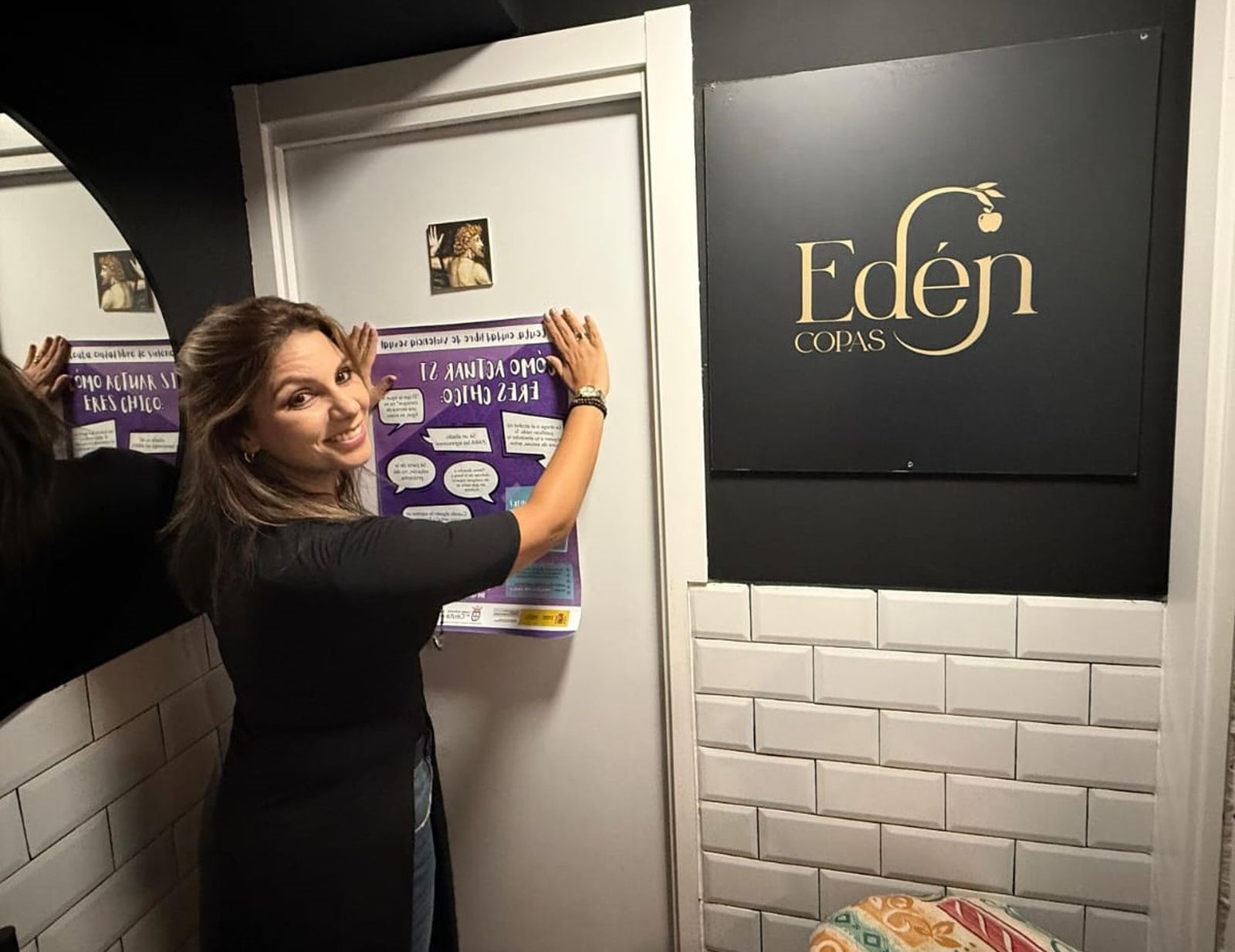 La consejera Nabila Benzina pegando un cartel relacionado con el 'punto violeta' en el Edén