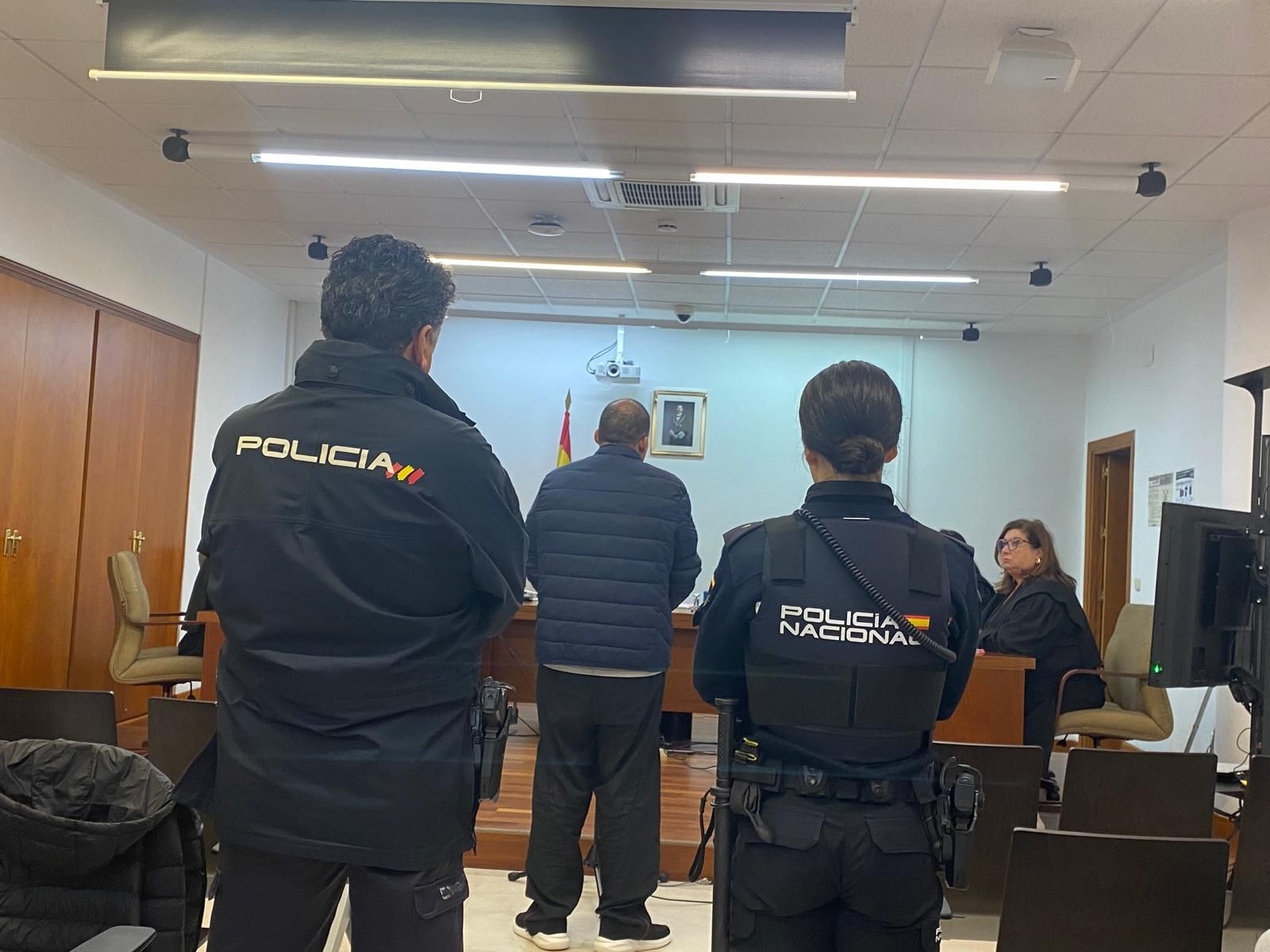 El investigado comparece conducido por dos policías.