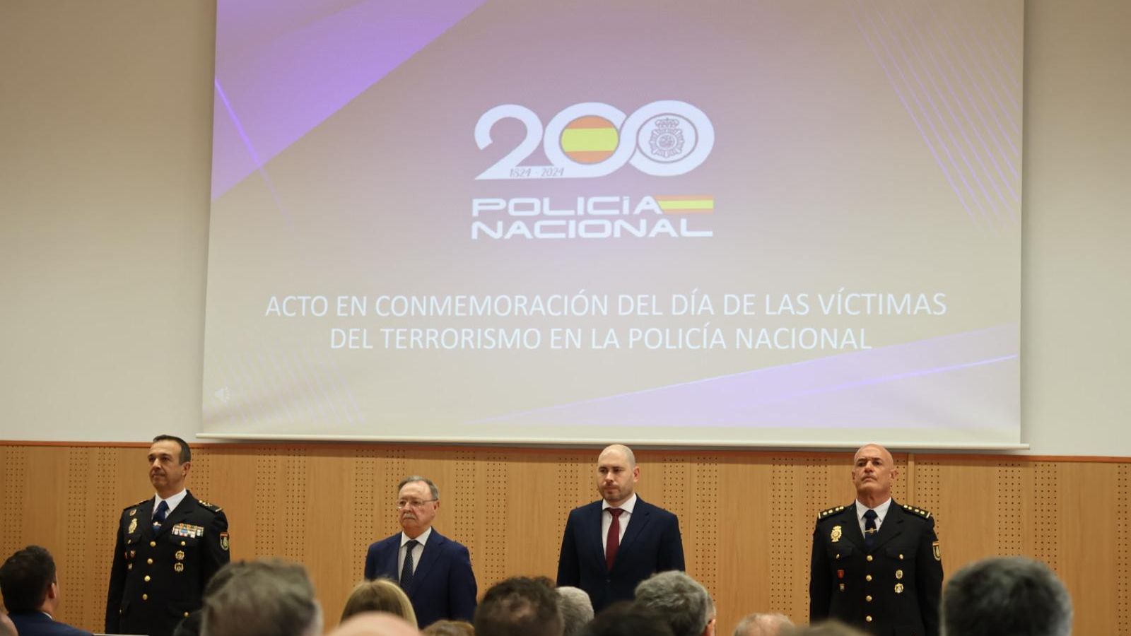 Román, Vivas y Triano durante el himno de España en el acto.