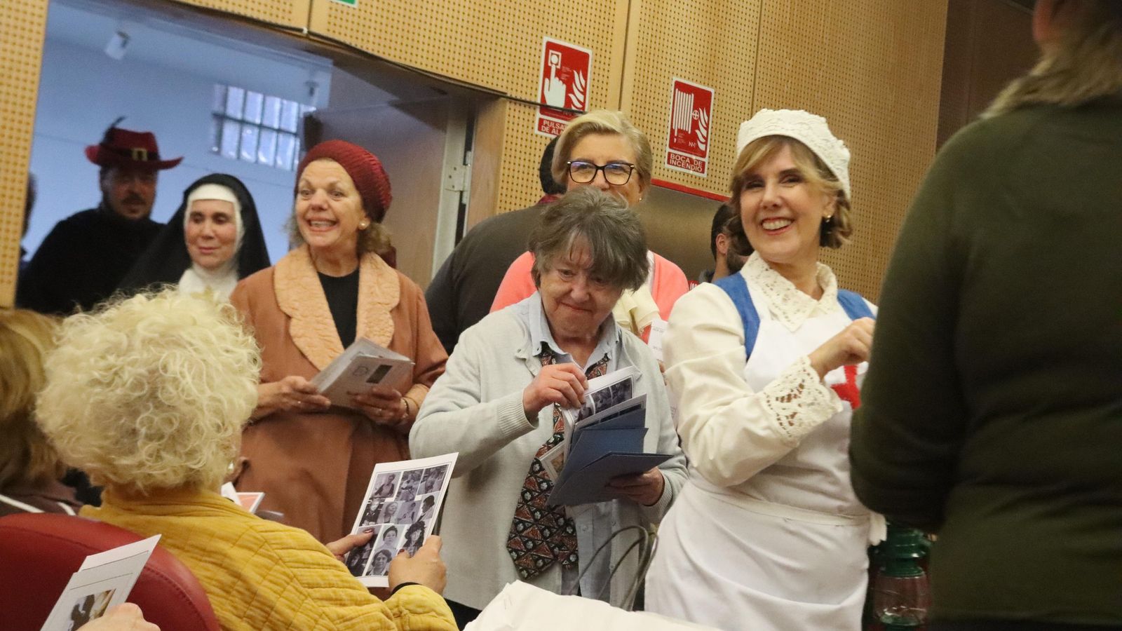 Las artistas entran al Salón de  Actos repartiendo el programa