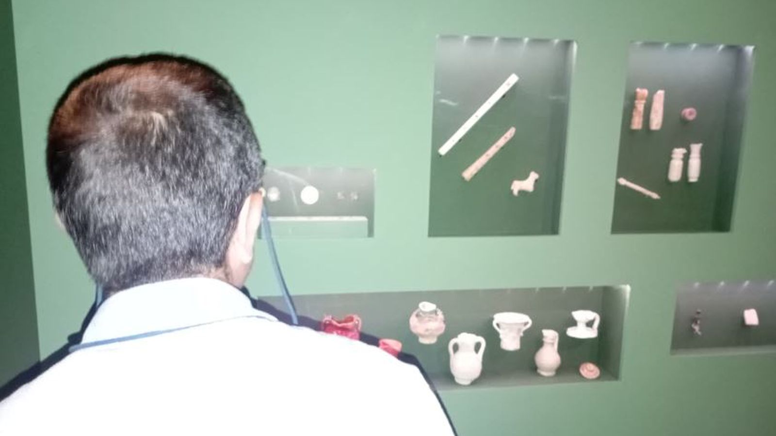 Un hombre observa algunas de las piezas expuestas en la muestra