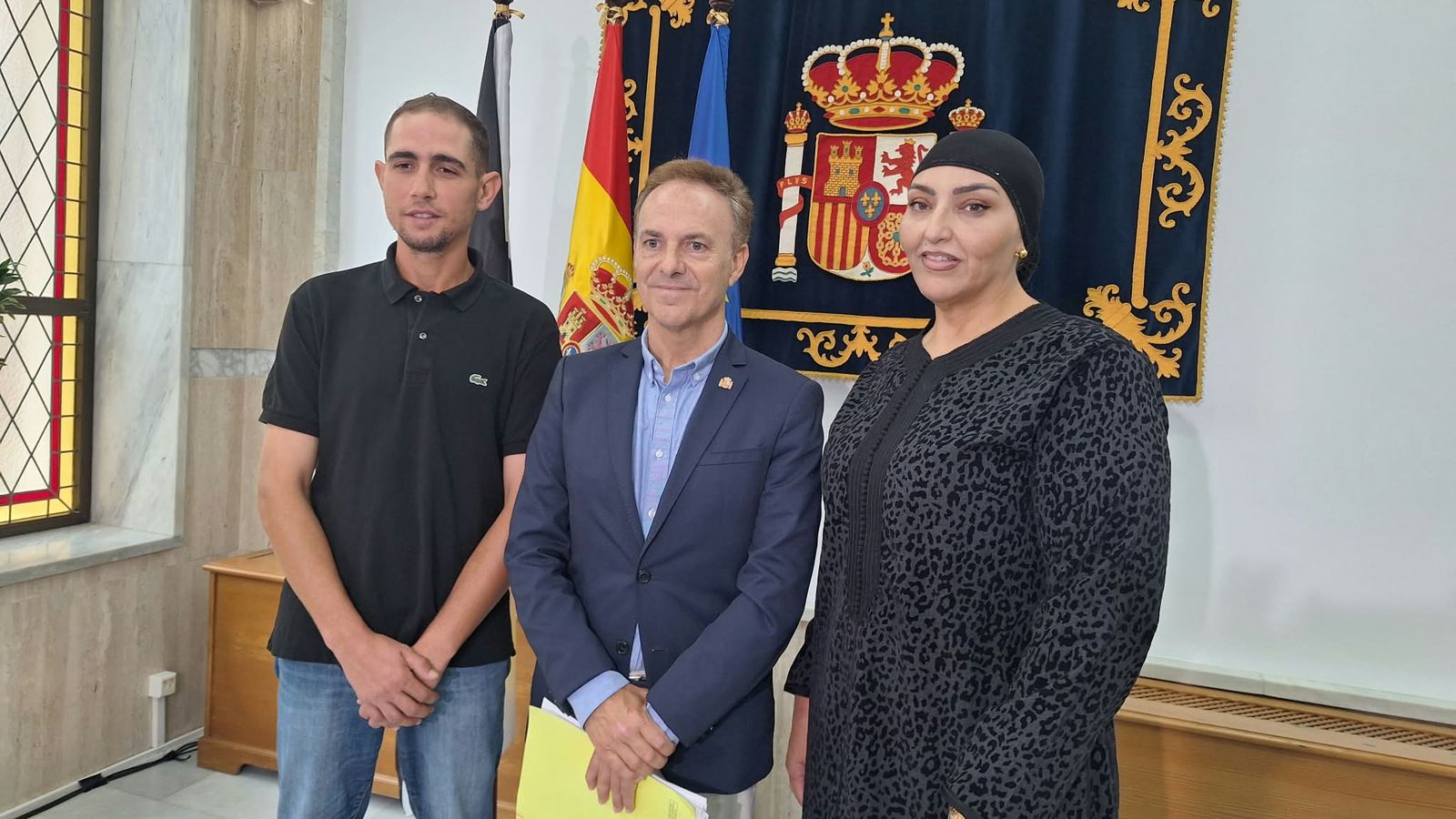 El delegado del Gobierno en Ceuta, David De la Encina, comparece junto a dos vecinos del Poblado de Regulares, Aisha y Omar