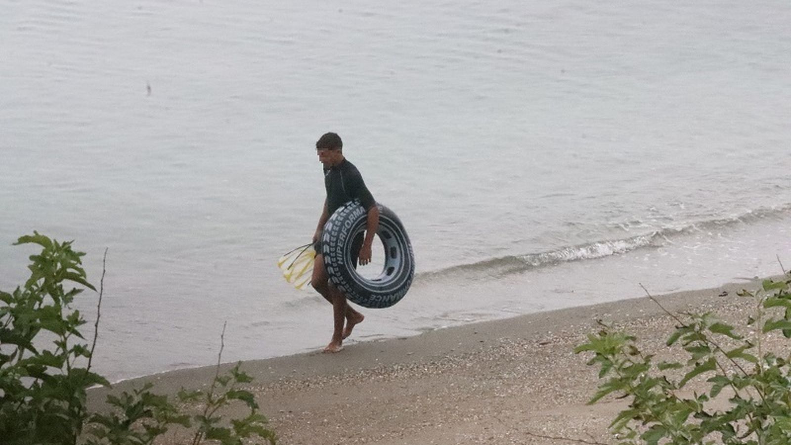 Un menor marroquí en la playa portando un flotador. Un menor marroquí en la playa portando un flotador.