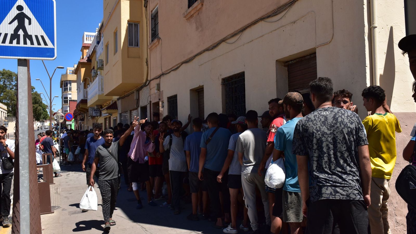 Cola para acceder a la casa de Sabah Hamed, donde alimentan y se asean las personas migrantes que siguen en Ceuta