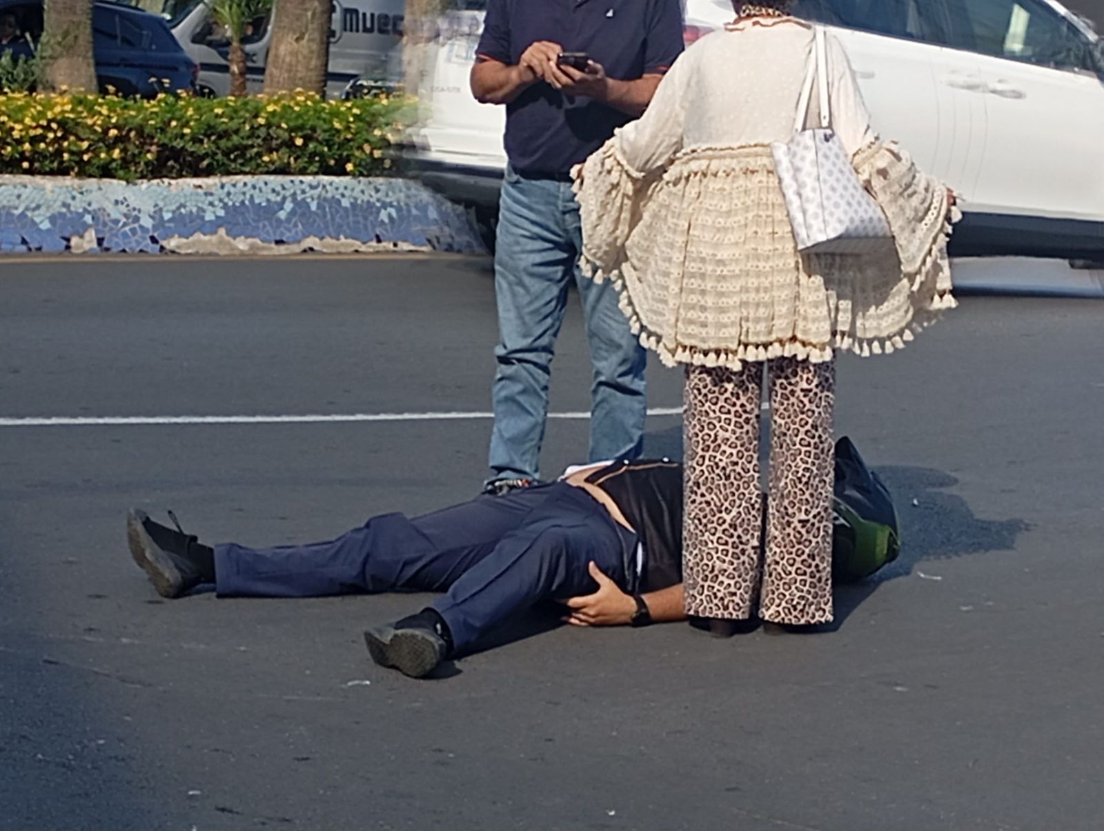 El motorista herido en la carretera junto a dos testigos del accidente