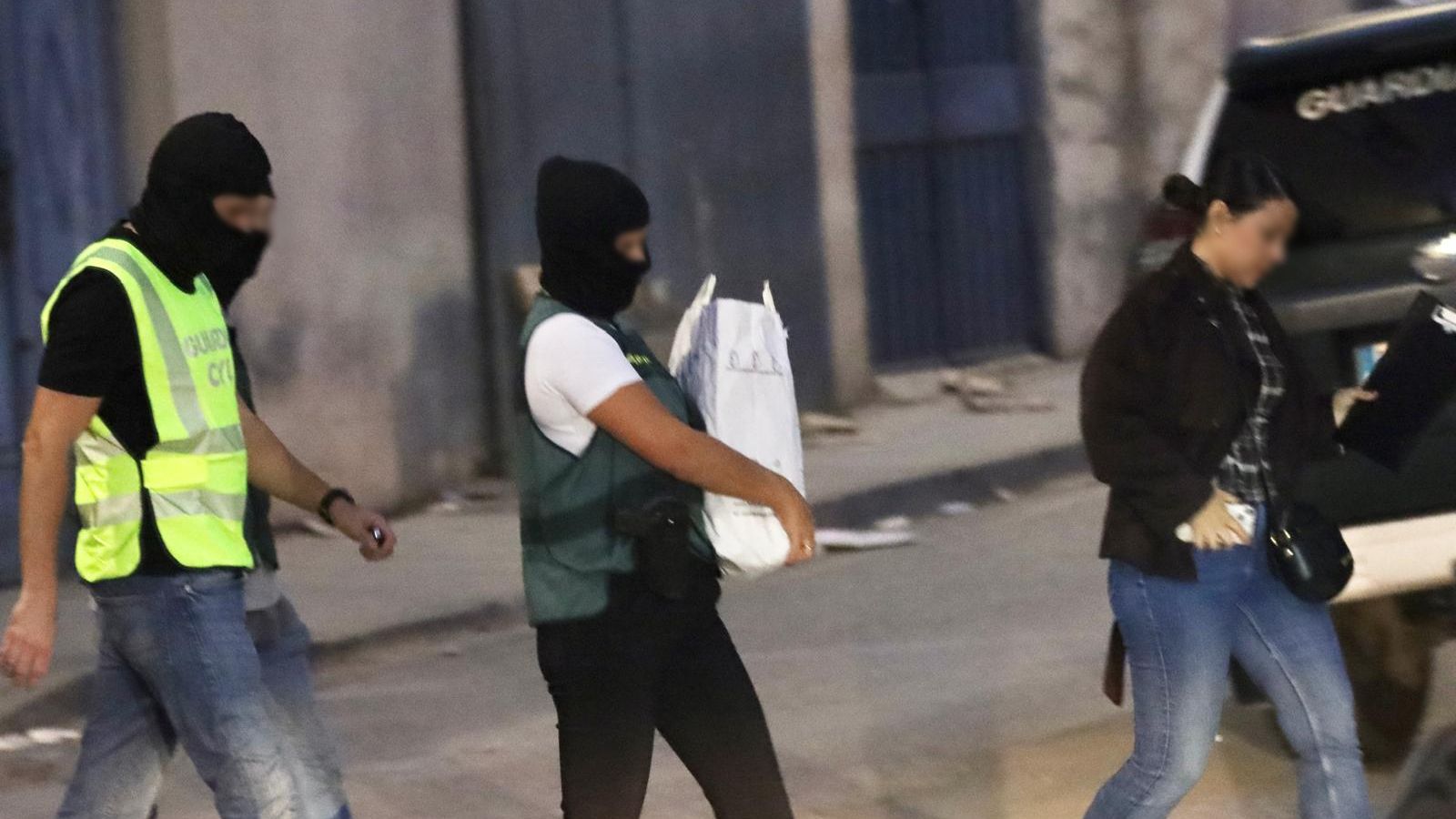 Agentes de la Guardia Civil sacan material del lugar de los hechos