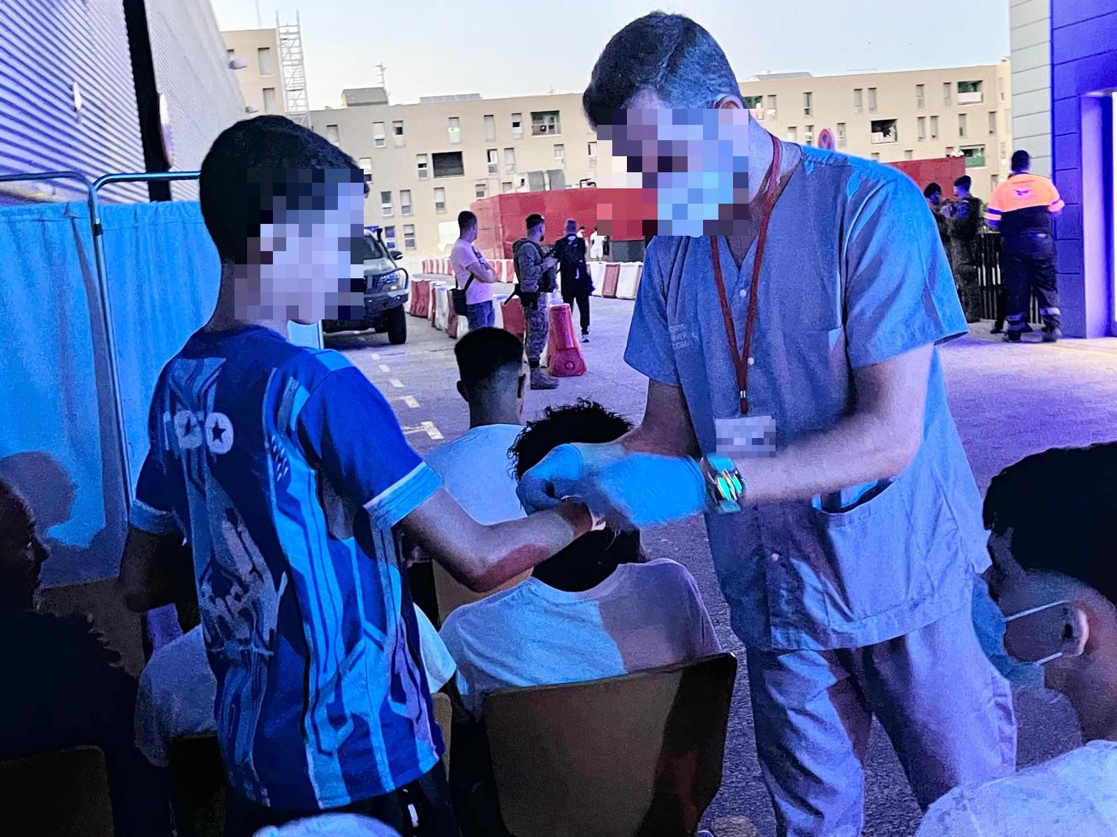 Un sanitario atiende a un joven migrante a las puertas de Urgencias