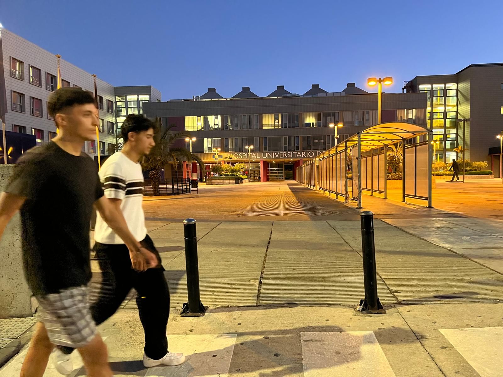 Dos migrantes caminan frente al Hospital Universitario de Ceuta