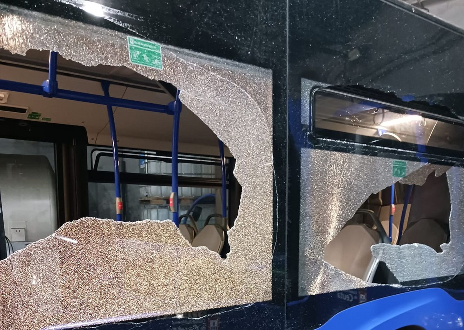 Imagen del autobús atacado con las dos lunas totalmente destrozadas