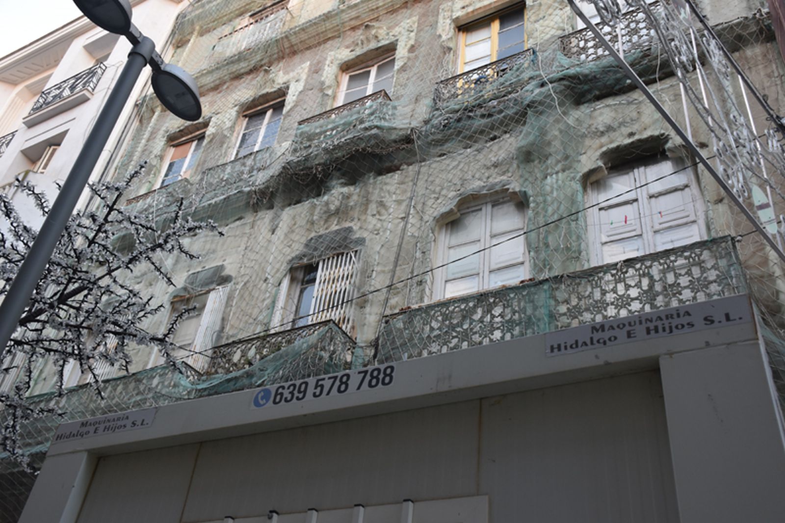 La caseta instalada por Amgevicesa para vigilar el edificio las 24 horas del día junto a los adornos navideños de la calle. / FOTO G.S.