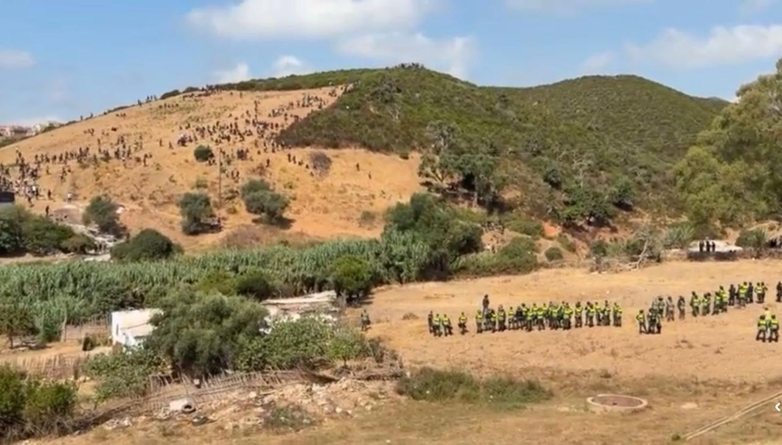 Autoridades marroquíes desplegadas en el monte próximo a Castillejos controlando a la masa de migrantes que trataba de avanzar hacia la frontera
