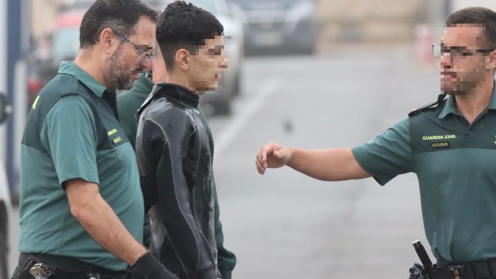 Agentes junto al migrante que llegó este domingo a Ceuta a nado Agentes junto al migrante que llegó este domingo a Ceuta a nado