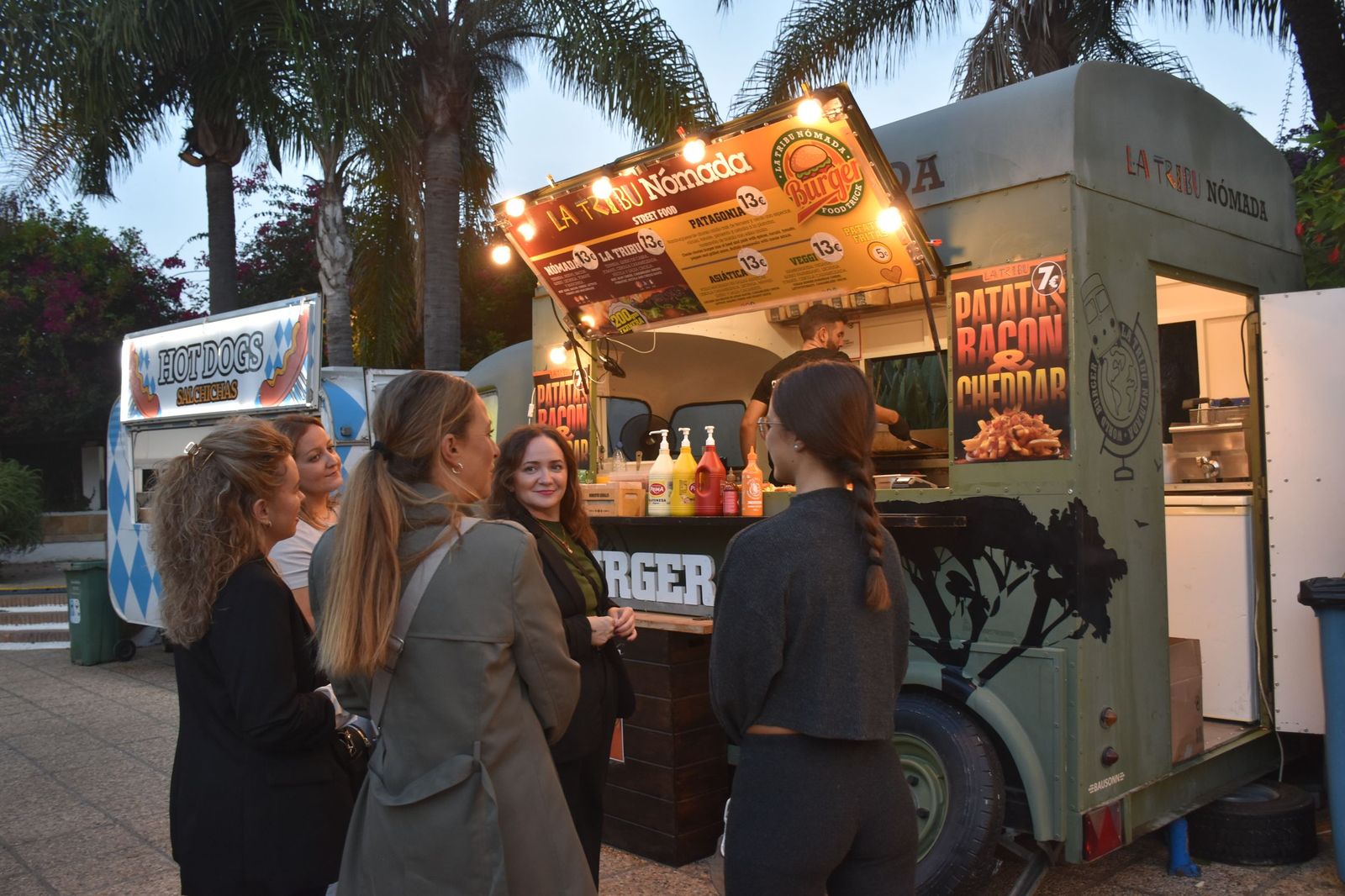 Un grupo de mujeres disfruta de la inauguración del primer 'Food Truck Festival. Sabores del mundo sobre ruedas’ en el Parque Marítimo