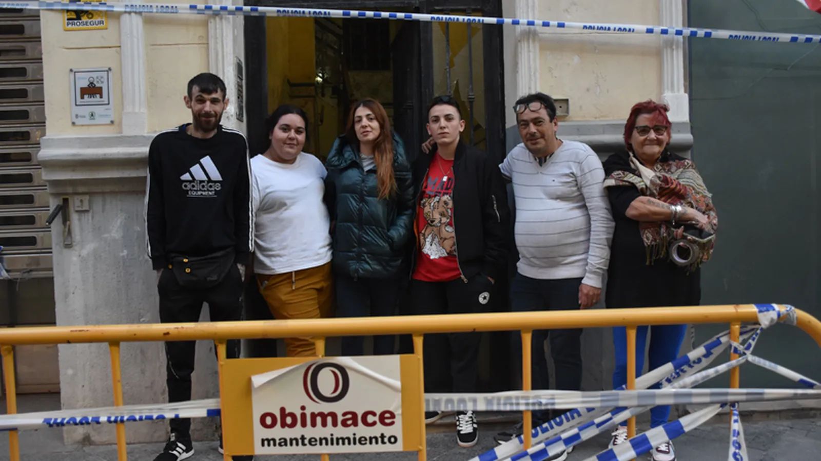 Varios vecinos del número 4 de González de la Vega posan a las puertas del edificio, acordonado tras la declaración de ruina técnica