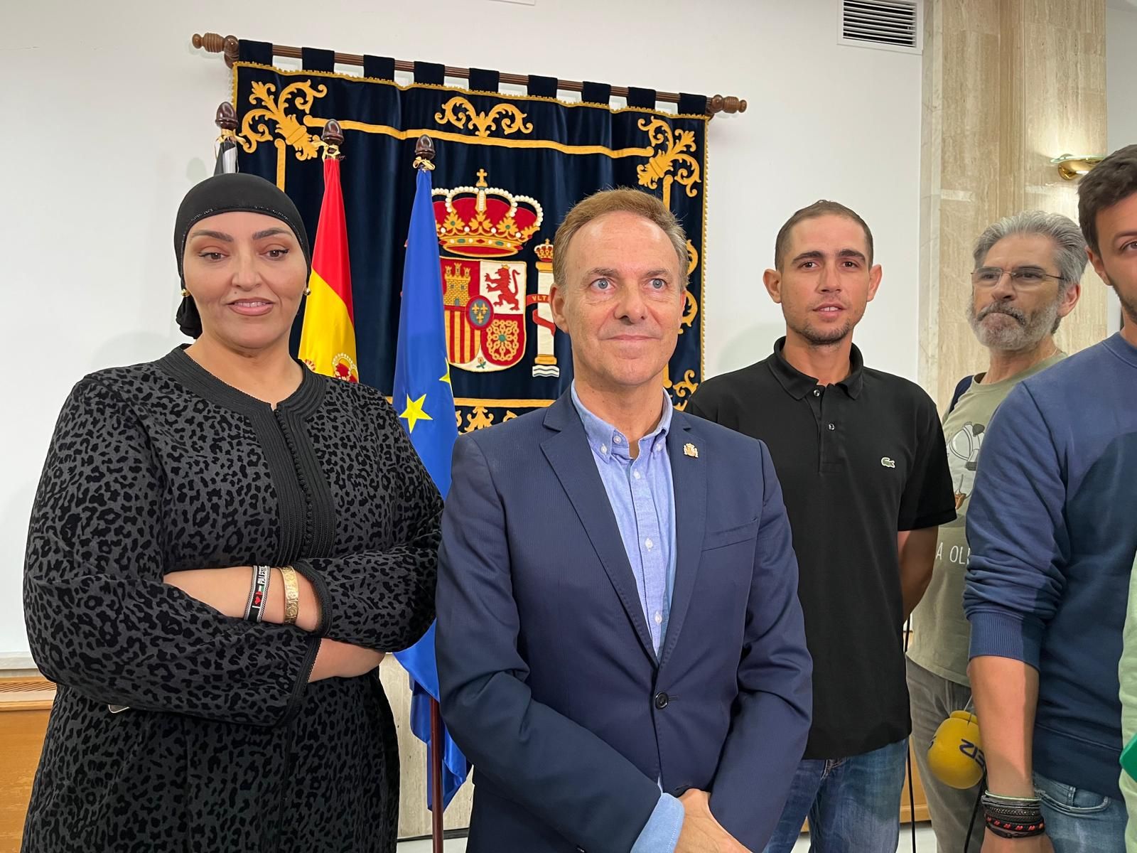 El delegado del Gobierno en Ceuta, David De la Encina, comparece junto a dos vecinos del Poblado de Regulares, Aisha y Omar