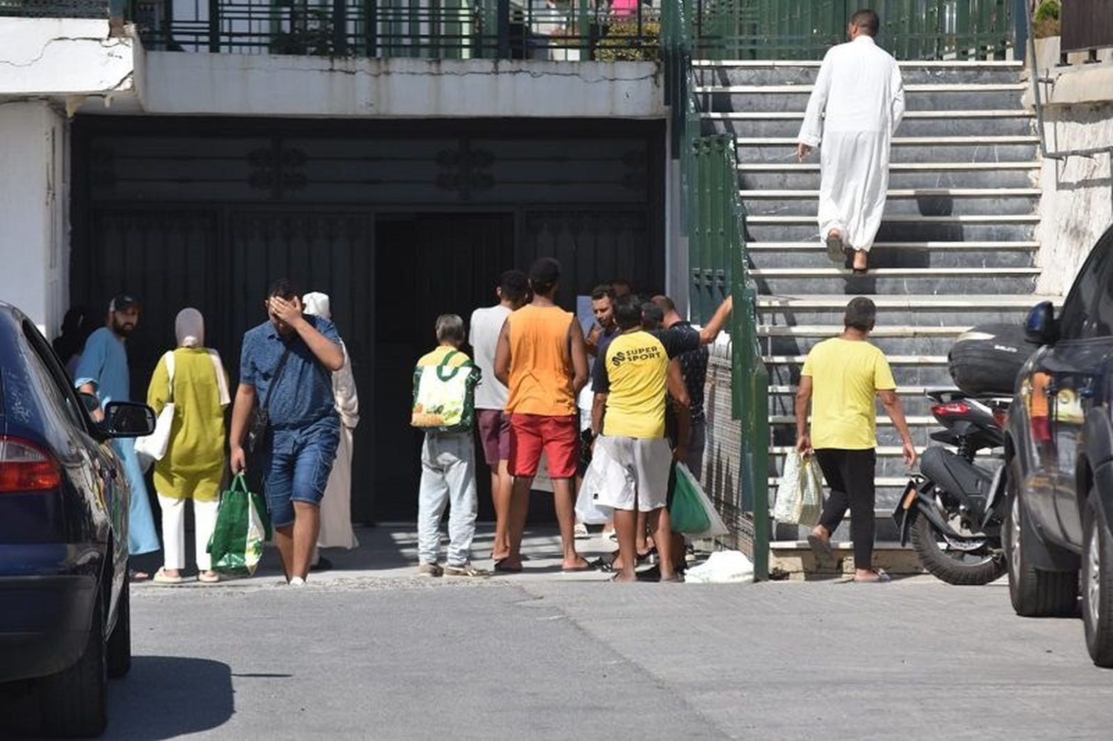 Gente en Ceuta haciendo cola en el comedor social situado en los bajos de Sidi Embarek