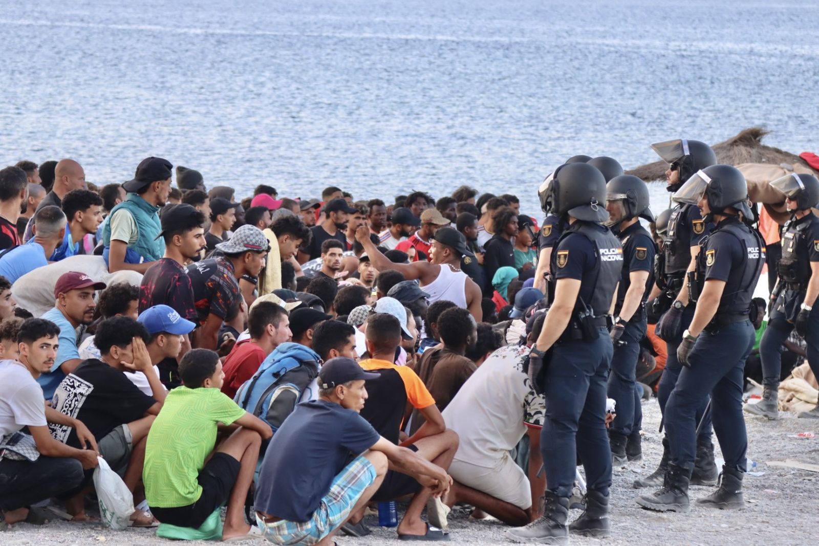 Migrantes en la playa del Trampolín, controlados por la Policía Nacional