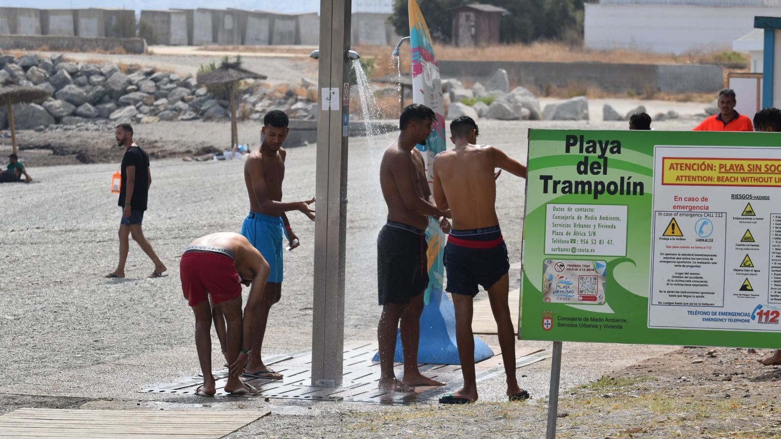 Migrantes magrebíes duchándose en la playa del Trampolín tras acceder a Ceuta