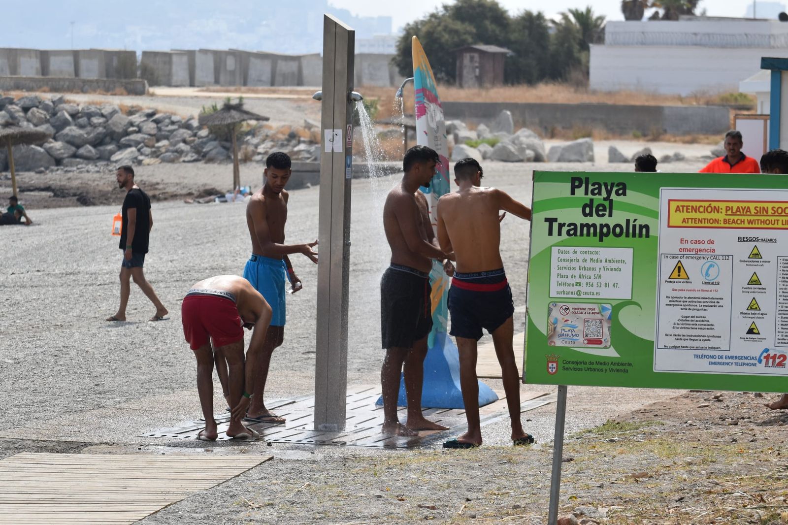 Migrantes magrebíes duchándose en la playa del Trampolín tras acceder a Ceuta
