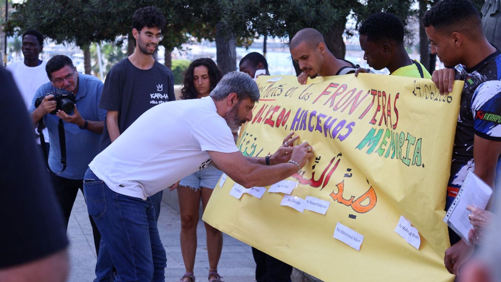 El líder de Ceuta Ya!, Mohamed Mustafa, pegando un papel con el nombre de una víctima