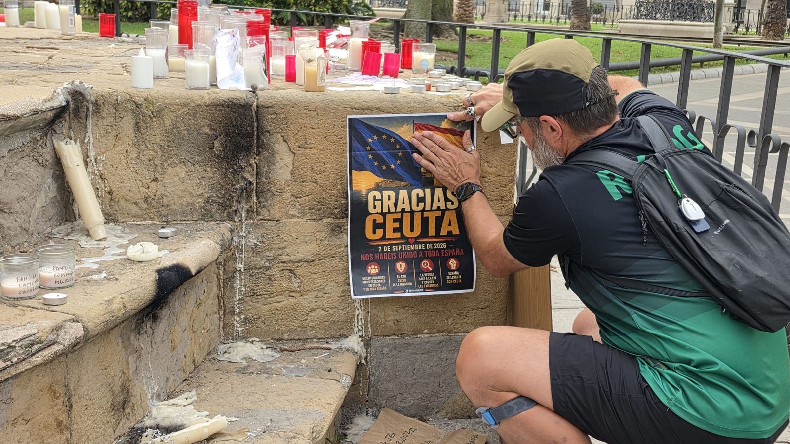 Miguel pegando un cartel en la plaza de África, en pleno corazón de Ceuta