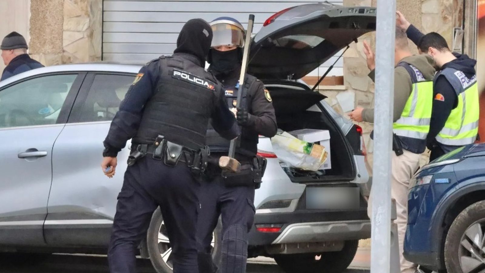 Un agente entregando una maza a otro durante el operativo en Benítez