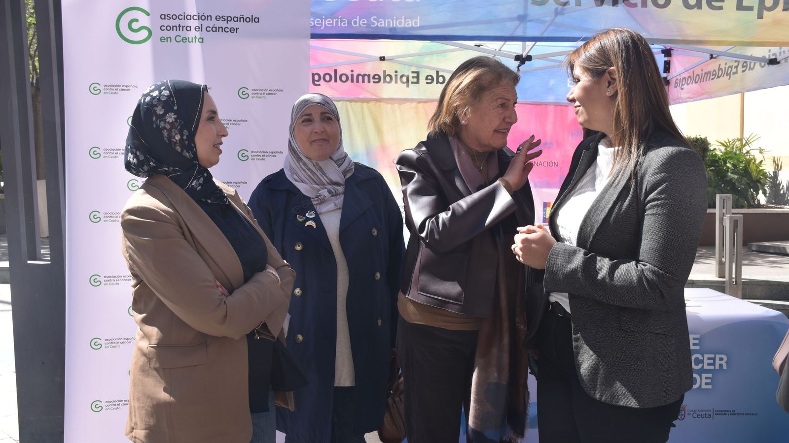 La consejera de Sanidad, Nabila Benzina, y la directora del área, Rebeca Benarroch, junto a Fatima Hamed y Nadia Mohamed, del MDyC, en el stand de la AECC en la Plaza de los Reyes con motivo del Día Mundial del Cáncer de Colon