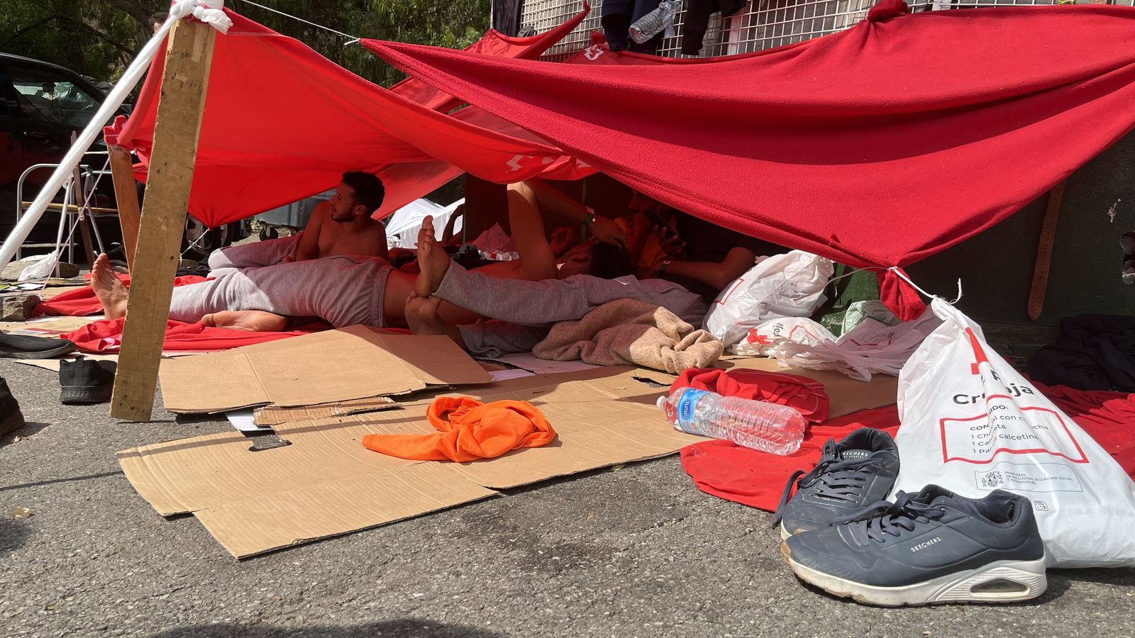 Personas migrantes esperando a las puertas del CETI su ingreso en las instalaciones