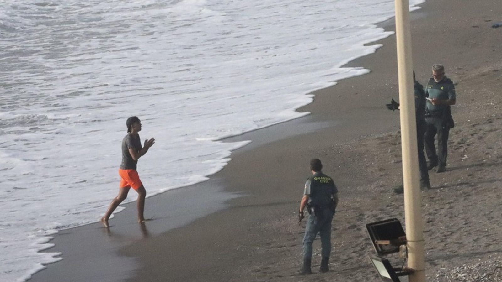 Un migrante que acababa de entrar a Ceuta dirigiéndose a varios Guardias Civiles. / FOTO REDUAN