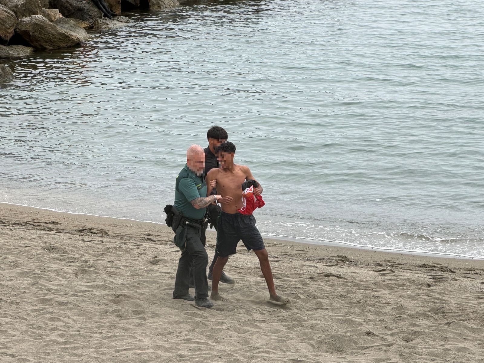 Un agente de la Guardia Civil intercepta a un migrante que acababa de facilitar la entrada en Ceuta de otro joven