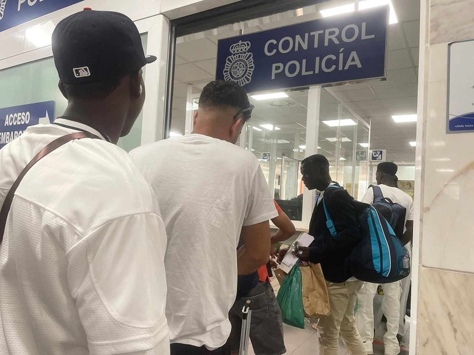 Un grupo de migrantes pasan el control policial de la Estación Marítima de Ceuta. / FOTO REDUAN