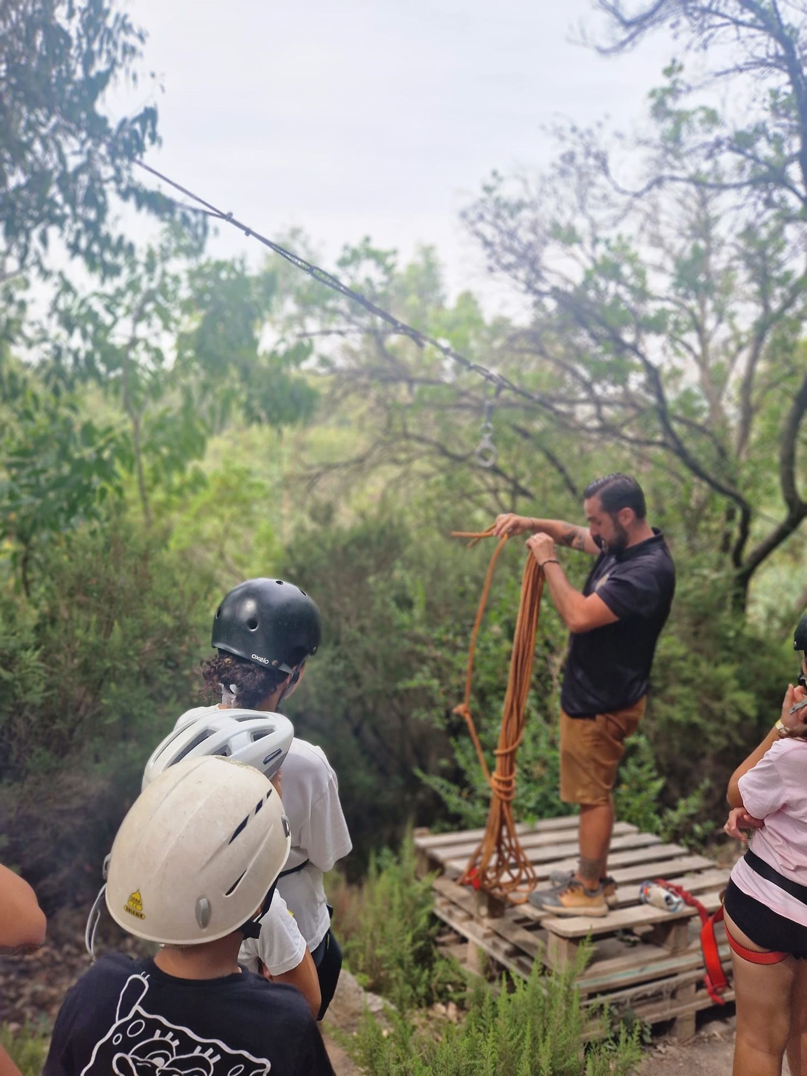 Un monitor del campamento prepara la tirolina para los niños