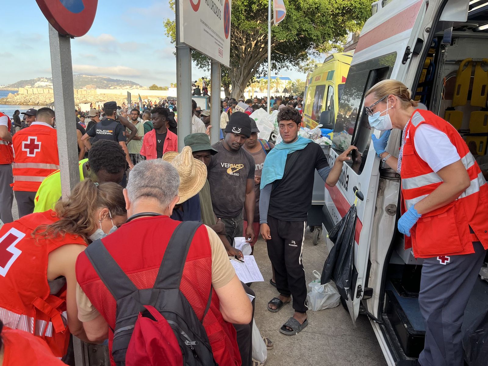 Voluntarios de Cruz Roja y trabajadores del INGESA atienden a migrantes en la playa del Trampolín