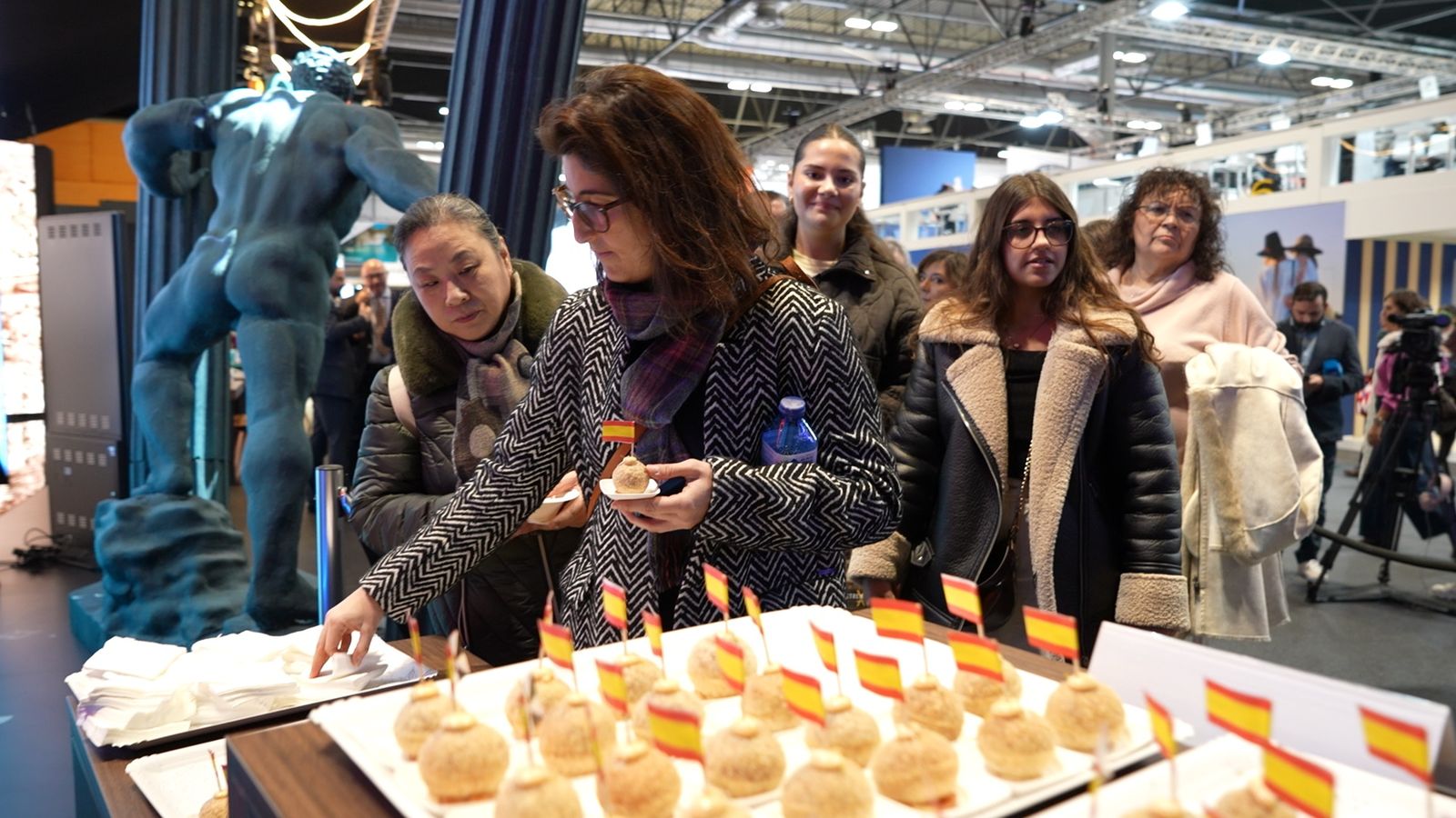 Visitantes degustan las tapas ofrecidas al público en el stand de Ceuta