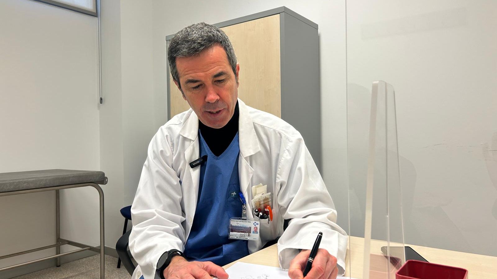 El hematólogo Rafael Aporta, en el interior de su consulta, explica gráficamente cómo se produce el cáncer