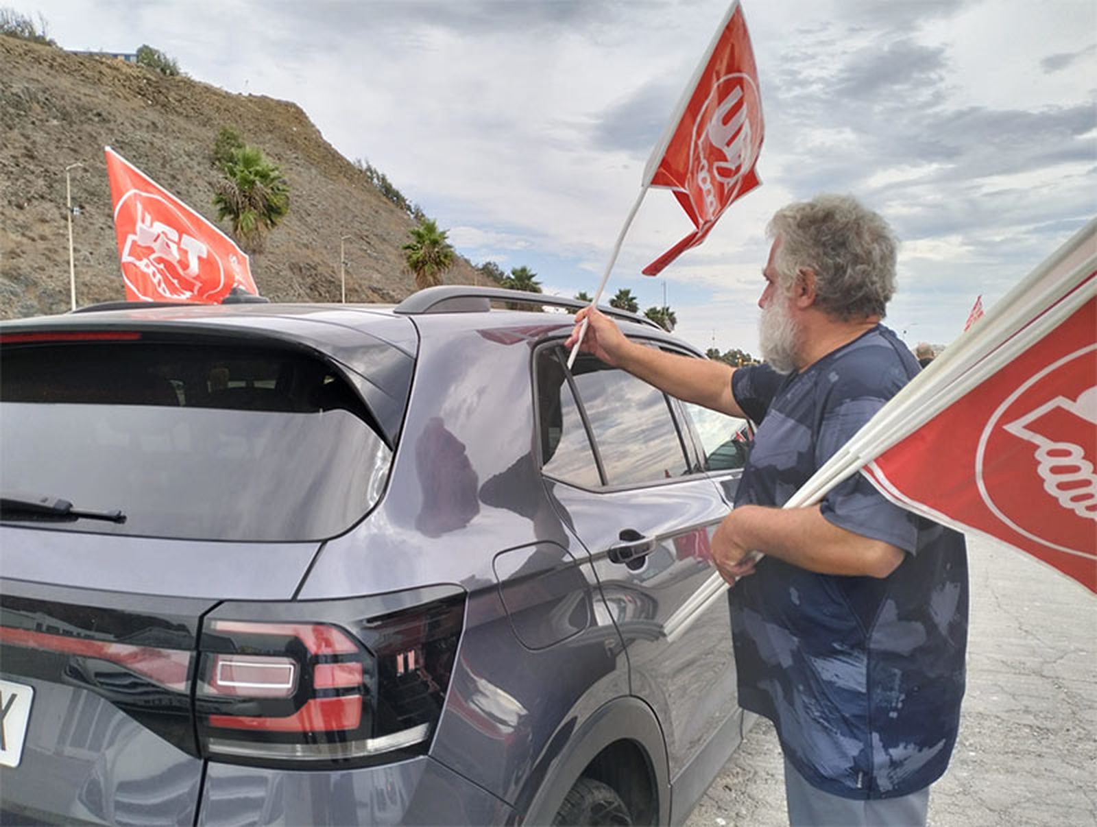 Un sindicalista coloca una banderola en un coche/FOTO EL PUEBLO