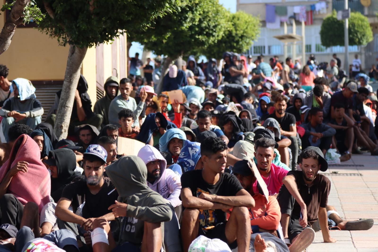 Migrantes a las puertas de la instalación de acogida en Loma Colmenar