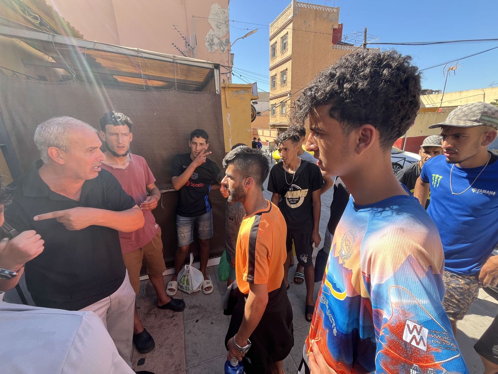 El presidente del Príncipe, Ahmed Efen-Dal, habla con migrantes que deambulan por su barriada