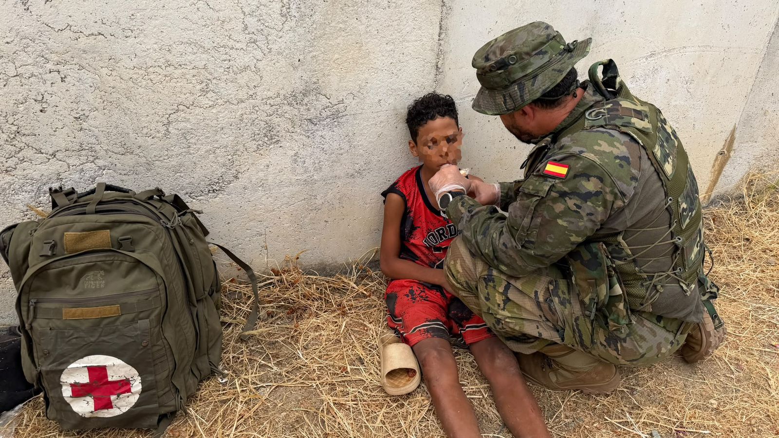 Un soldado atiende a un niño migrante