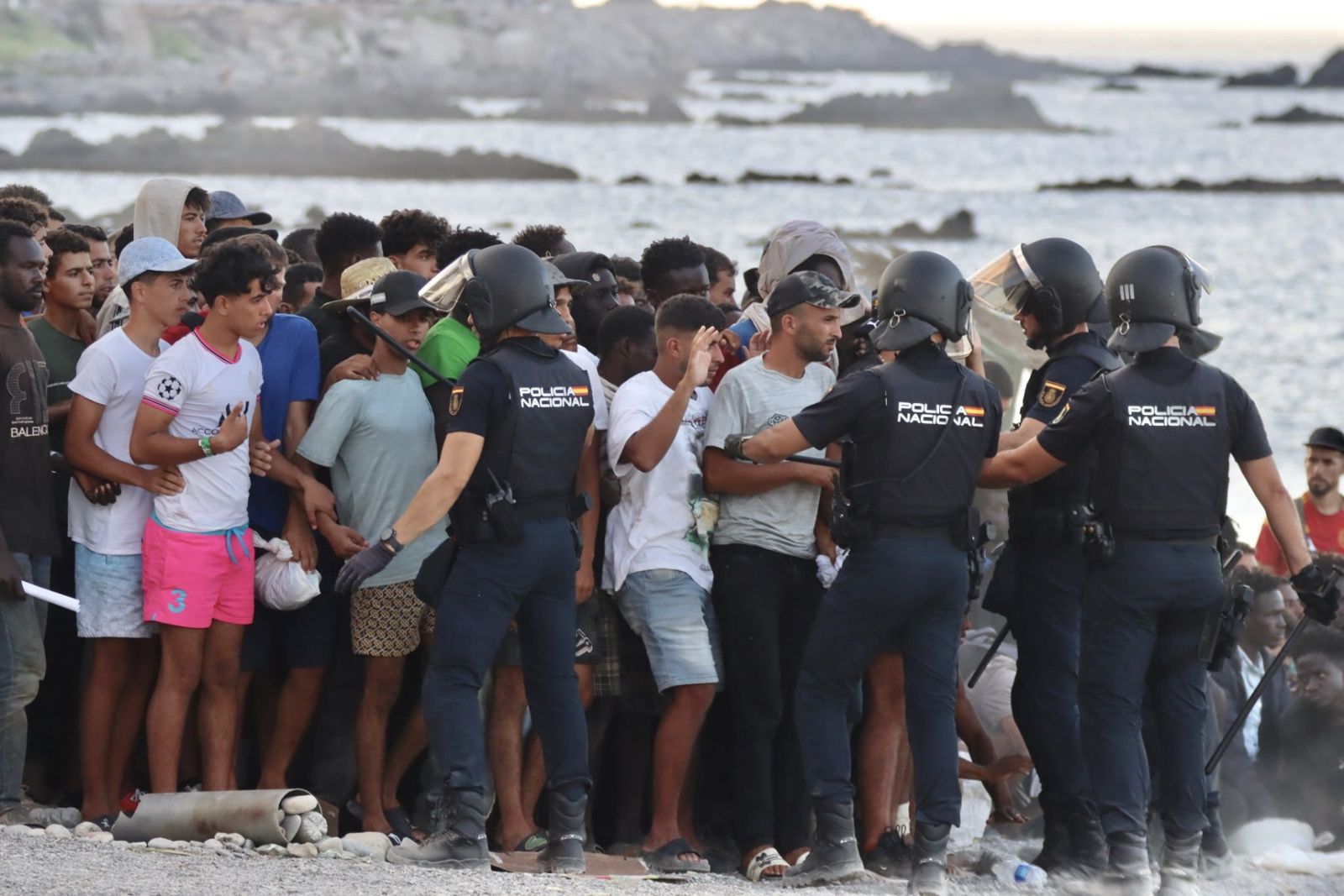Migrantes en la playa del Trampolín, controlados por la Policía Nacional