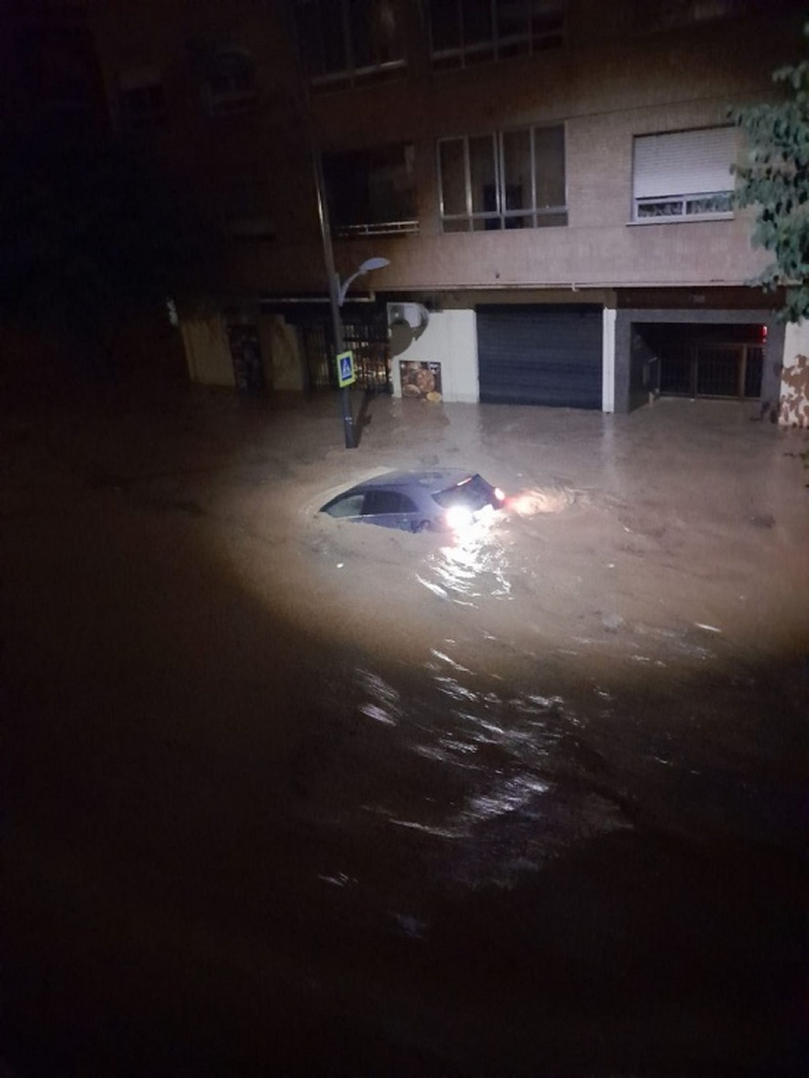 Un coche hundido bajo el agua en una calle de Valencia. / FOTO CEDIDA Un coche hundido bajo el agua en una calle de Valencia. / FOTO CEDIDA