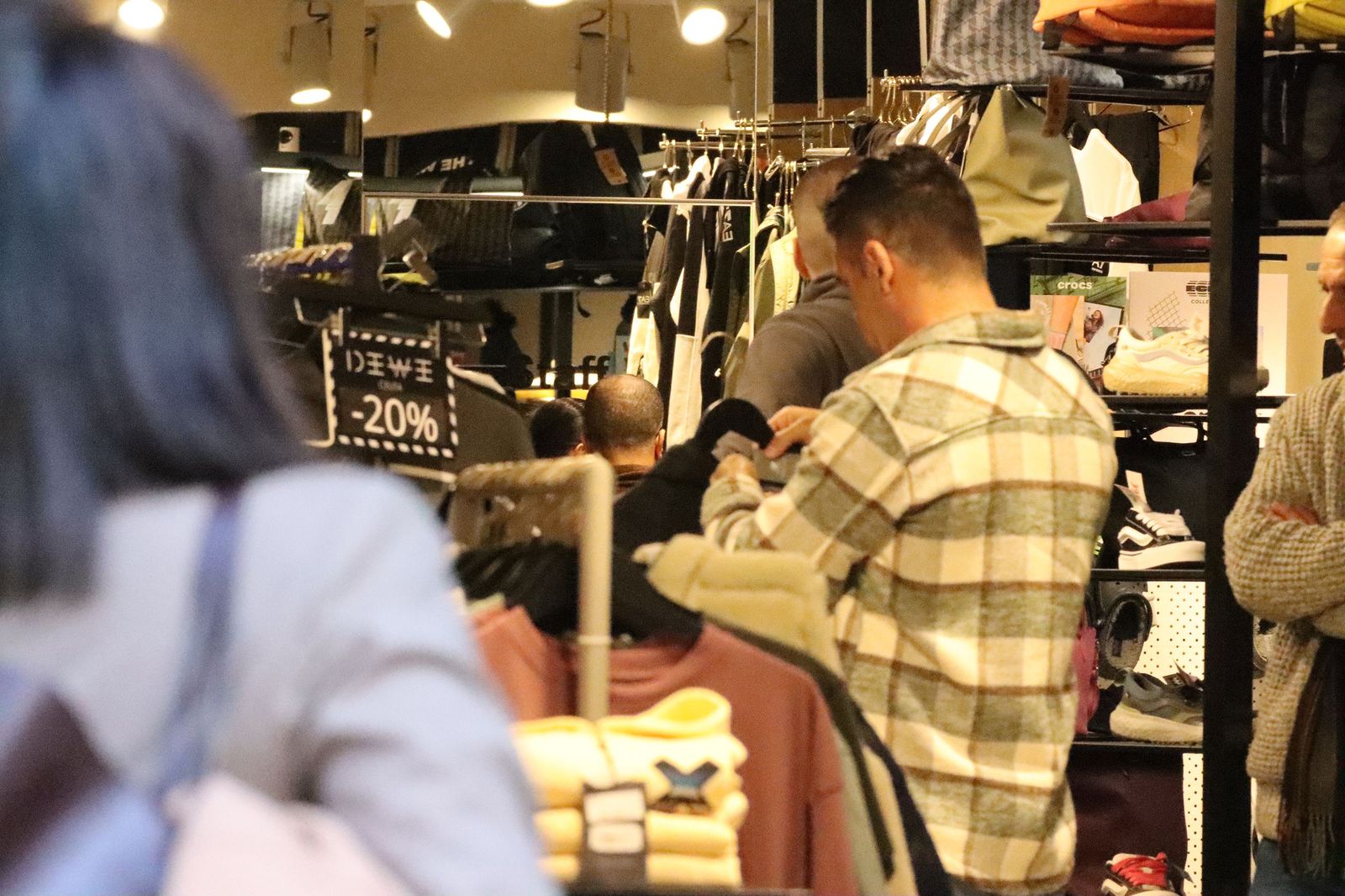 Un cliente inspecciona una prenda en un establecimiento comercial