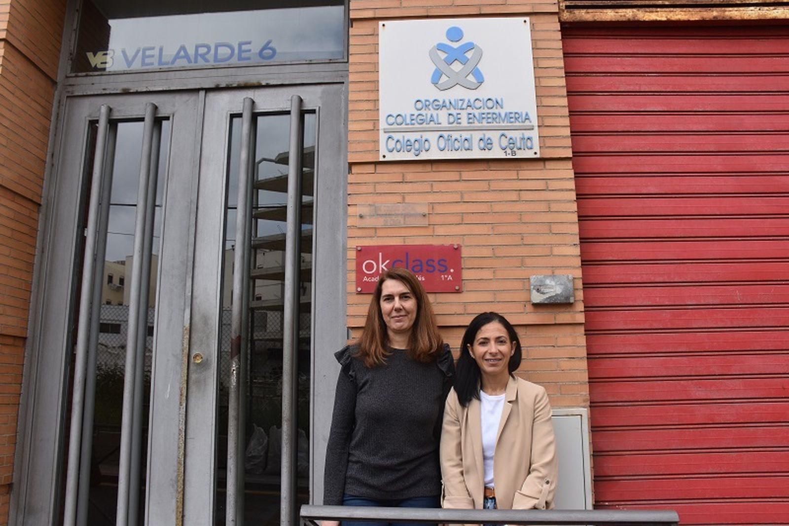 La presidenta del Colegio de Enfermería de Ceuta, Rosa Fuentes, y la secretaria, Inma Gaitán, junto a su sede, ubicada en la calle Velarde, número 6.