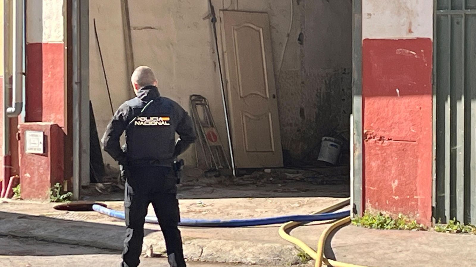 Un agente de la Policía Nacional en la nave donde se está achicando agua | REDUAN