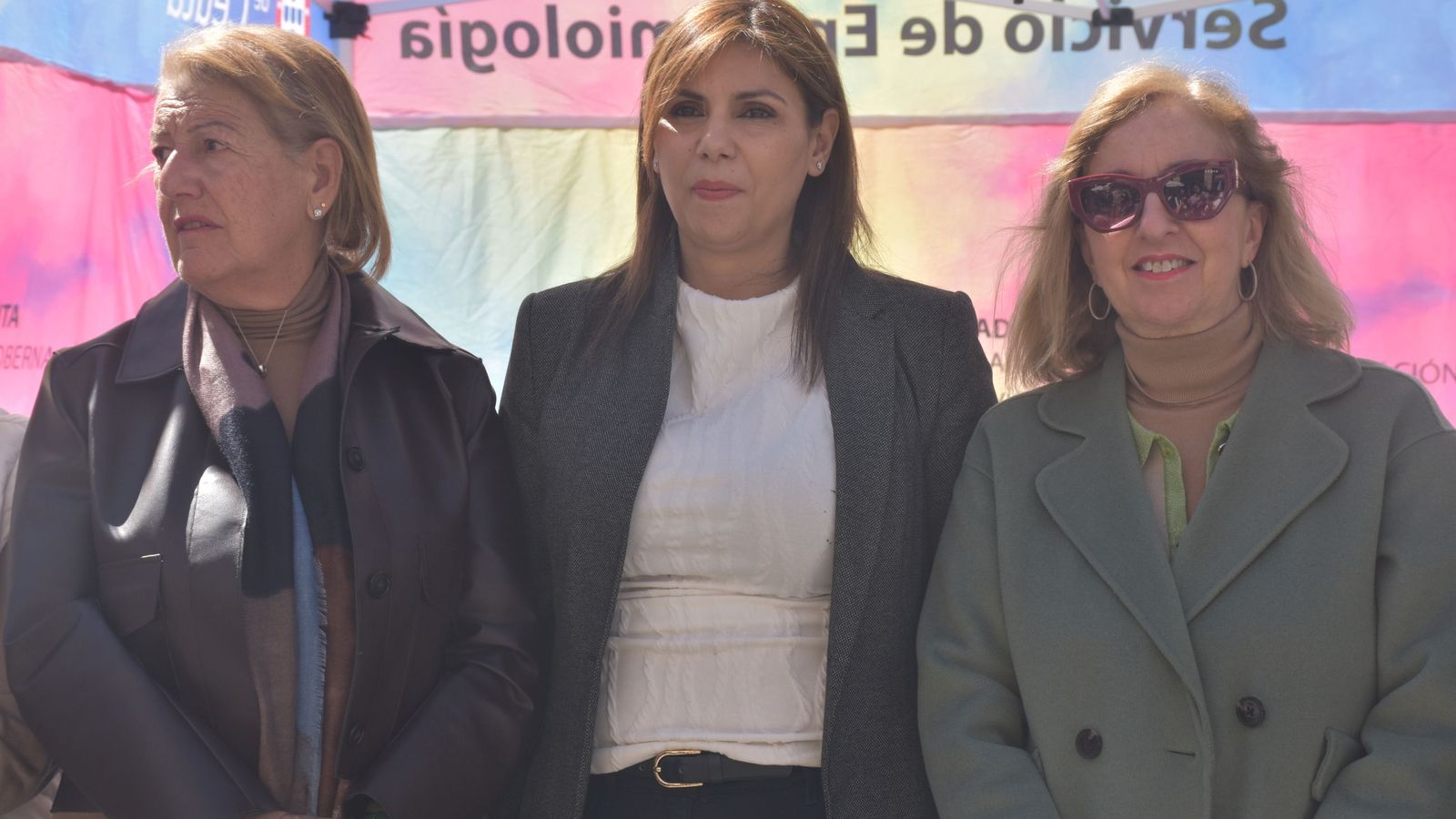 Las responsables de la Consejería de Sanidad y Servicios Sociales, Rebeca Benarroch, Nabila Benzina y Adela Nieto en el stand de la AECC en la Plaza de los Reyes con motivo del Día Mundial del Cáncer de Colon