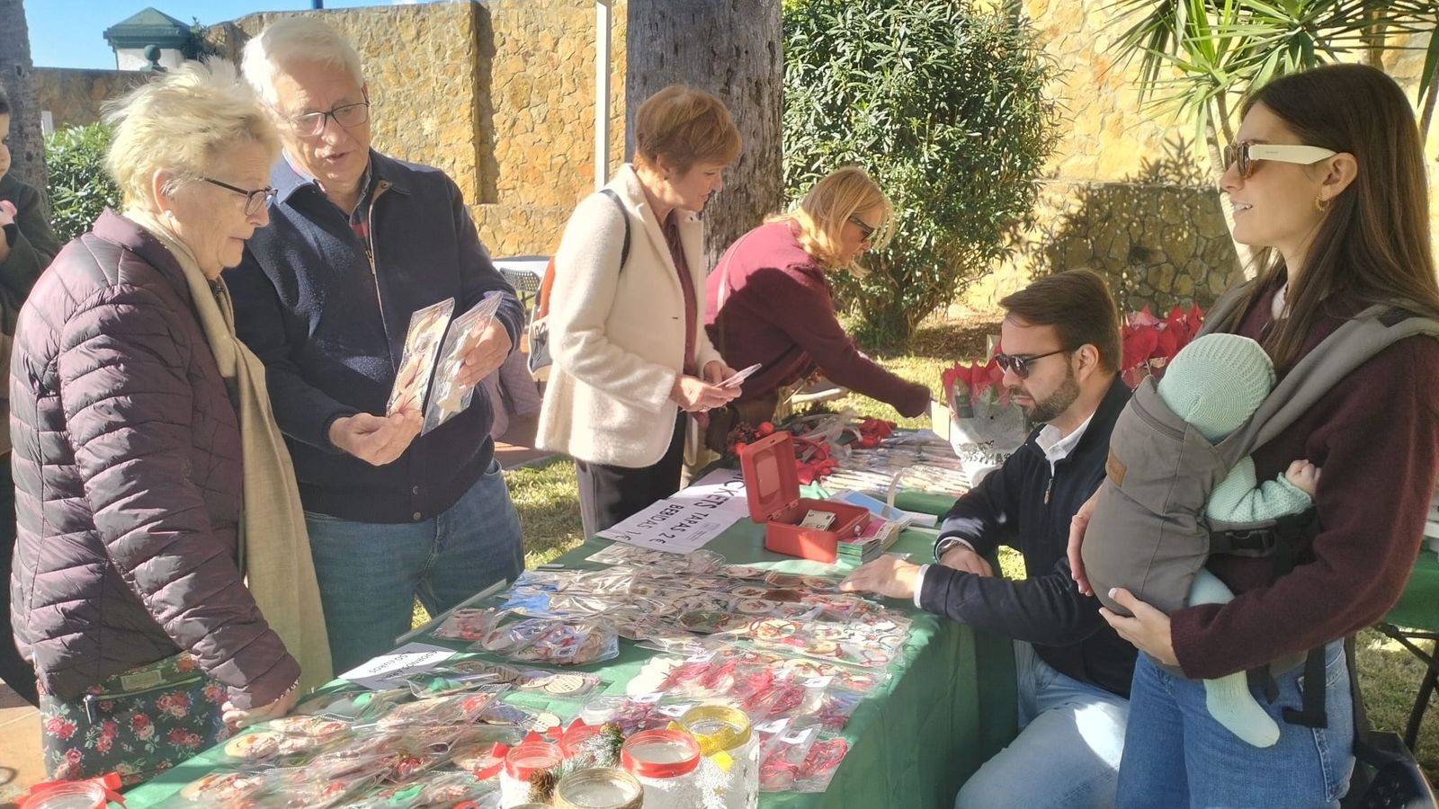 Algunos participantes curiosean entre los trabajos de los usuarios expuestos en los jardines de la Fundación