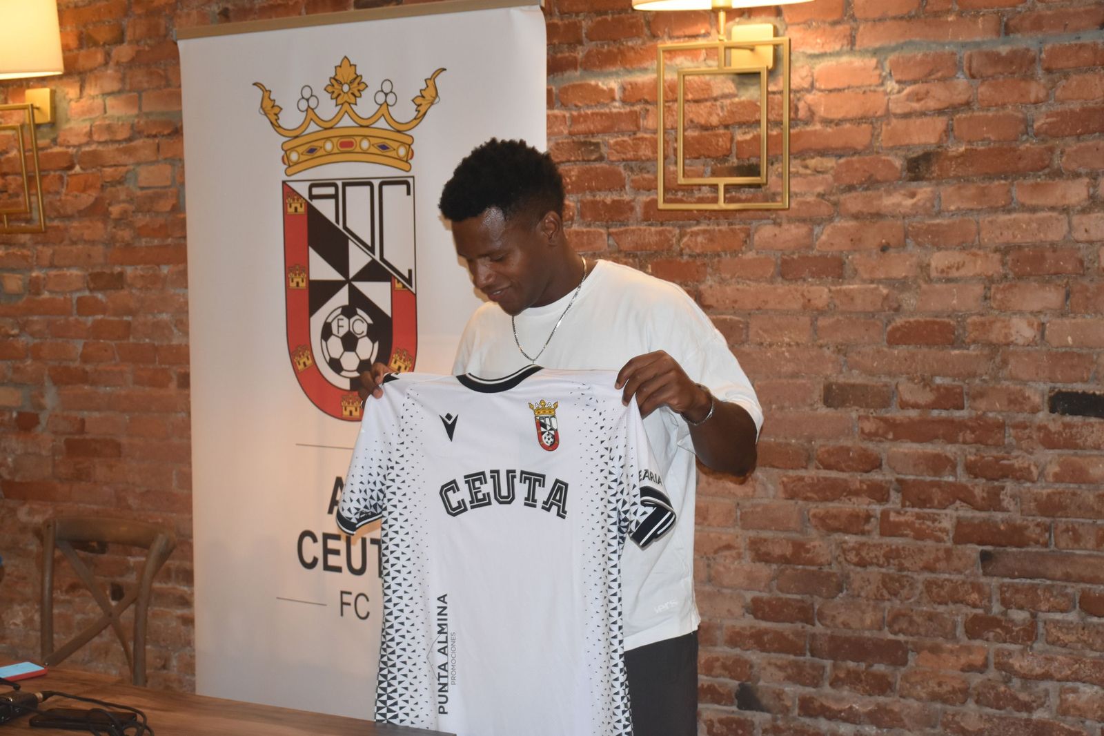 Cedric sonríe sujetando de nuevo la camiseta del Ceuta