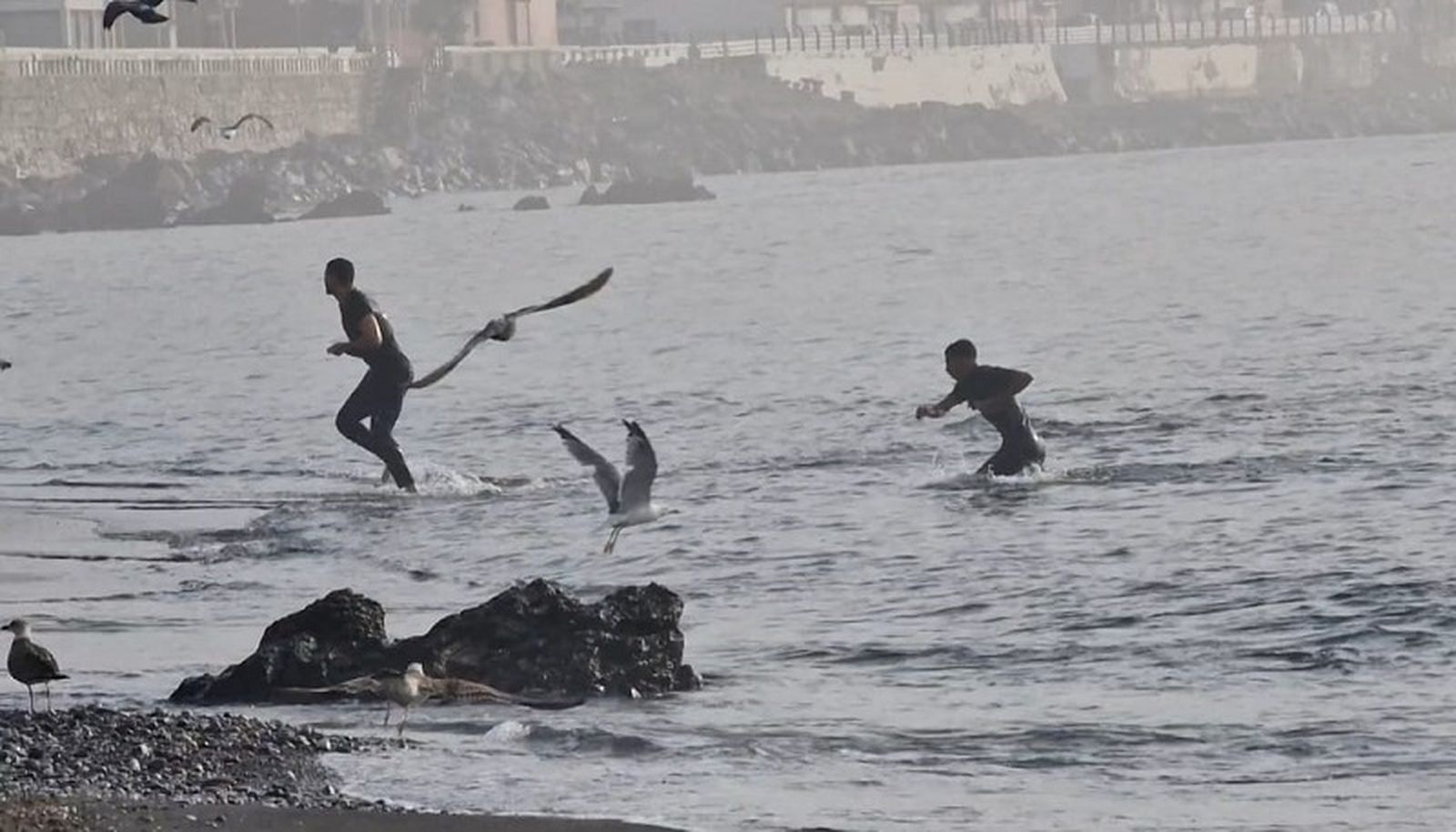Dos migrantes llegan a la orilla de la playa del Tarajal aprovechando la ausencia de agentes de seguridad. / FOTO S.D.
